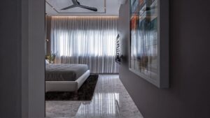 A house for sale in Ghana. A Bedroom view with just the lower part of the bed in showing. The top part of the bed blocked by a short wall potruding from the left side of the image