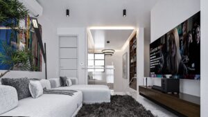 A house for Sale in Ghana. A living room view of a luxury house with a very wide TV mounted on the left wall and facing the white L-shaped sofa