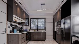A house for sale in Accra Ghana. Modern kitchen with a wooden laminated cabinet and all appliances built into the cabinets