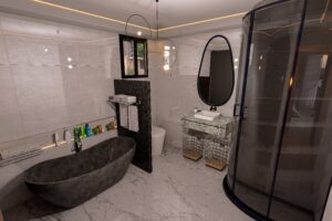 The bathroom of a 3 bedroom house for sale in Accra Ghana - It has a bath tub and a tinted glass shower cubicle - Regimanuel Satellite City