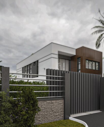 Houses For Sale in Accra with Off-Plan & Monthly Installments - A view from the front gate of a storey house. The walls are short with metal balusters that allow you to see the upper portion of the house.
