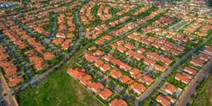 The best gated communities in Ghana – An aerial view of the Regimanuel Gray Estate in Accra. The houses, with their terracotta roofs, are neatly arranged and interspersed with trees and landscaping in front of each one.