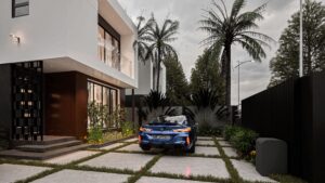The entrace view of the RGP 9 with a blue BMW car parked inside the house - The RGP 9 is a 4 bedroom house at Regimanuel Satellite City it is one of 8 different house types for sale are Regimanuel Satellite City in Accra, Ghana